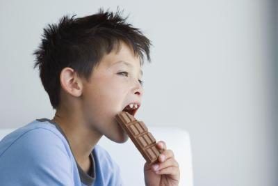Garçon manger une barre de chocolat