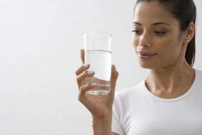 Femme tenant un verre d'eau salée