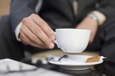 Un homme d'affaires boit une tasse de thé chaud.