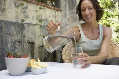 Femme versant un verre d'eau