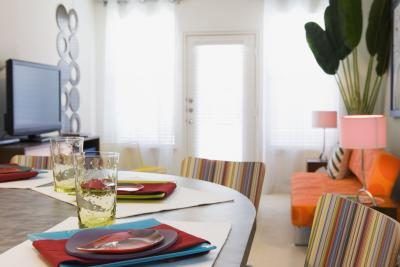 Une table de salle à manger est réglé avec des accents colorés qui correspondent à la salle de séjour.