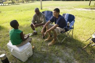 Deux hommes parlent à un jeune garçon sur un site de camp.